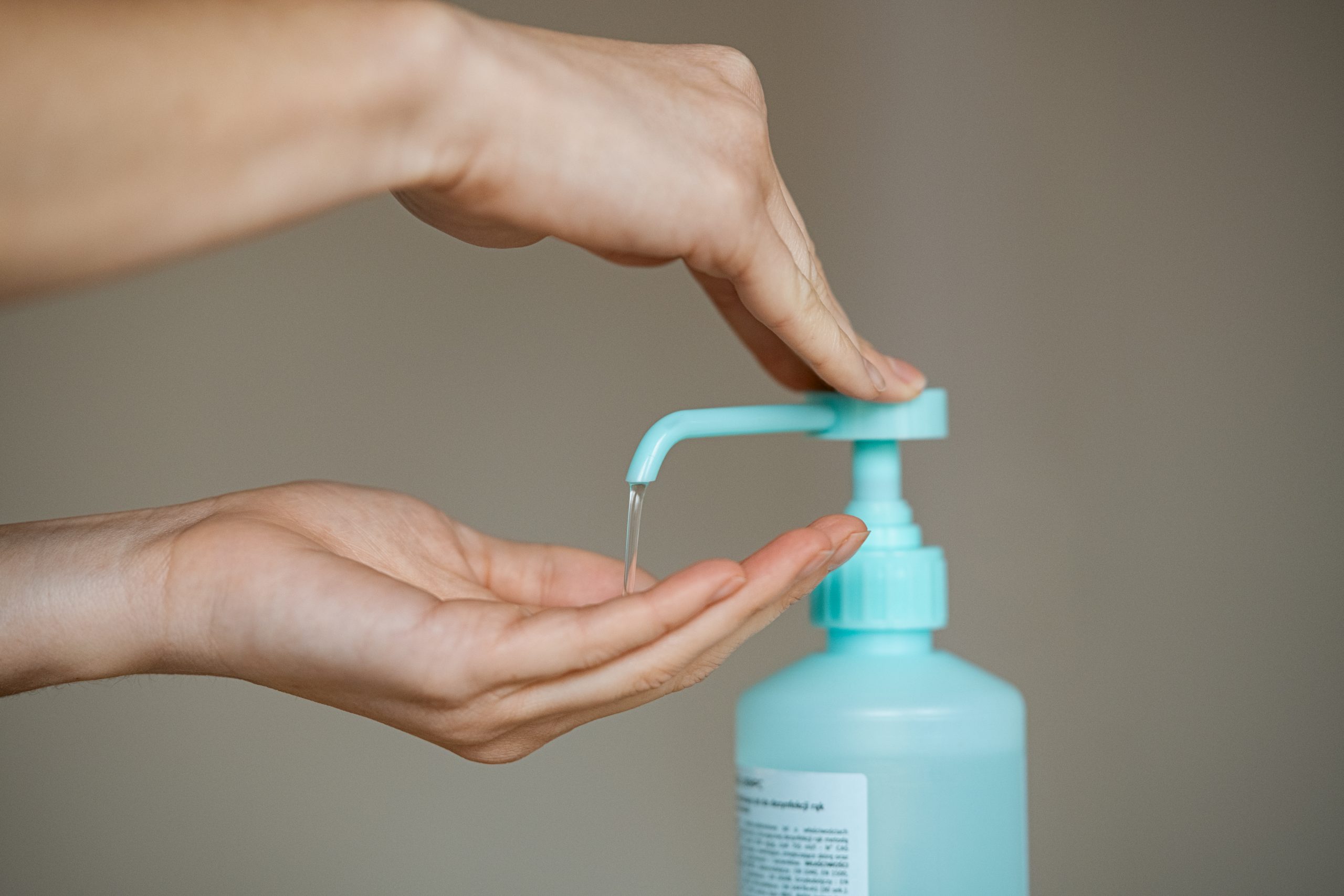 Close up of sanitizer gel pump dispenser for hand hygiene, virus and germs protection. Woman hands squeezing antibacterial and antiseptic hand sanitizer on hands. Prevent the spread of germs and bacteria and avoid infections corona virus.